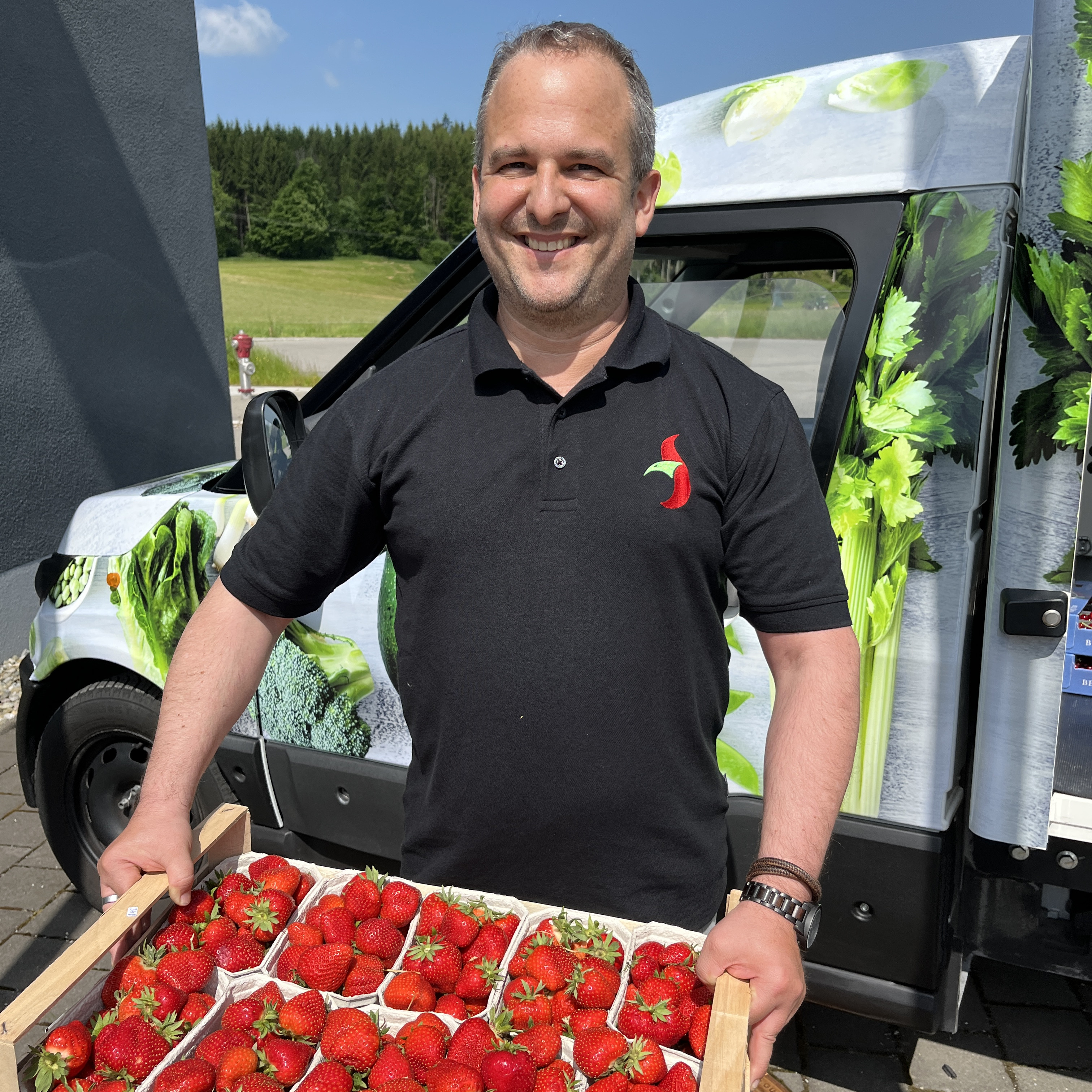 Mitarbeiter mit frischen Erdbeeren in den Händen